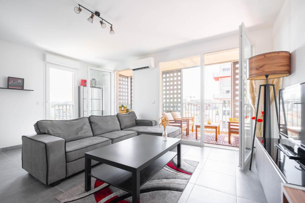 a living room with a couch and a table at T2 Entre plage et centre ville-Terrasse/Parking in Marseille