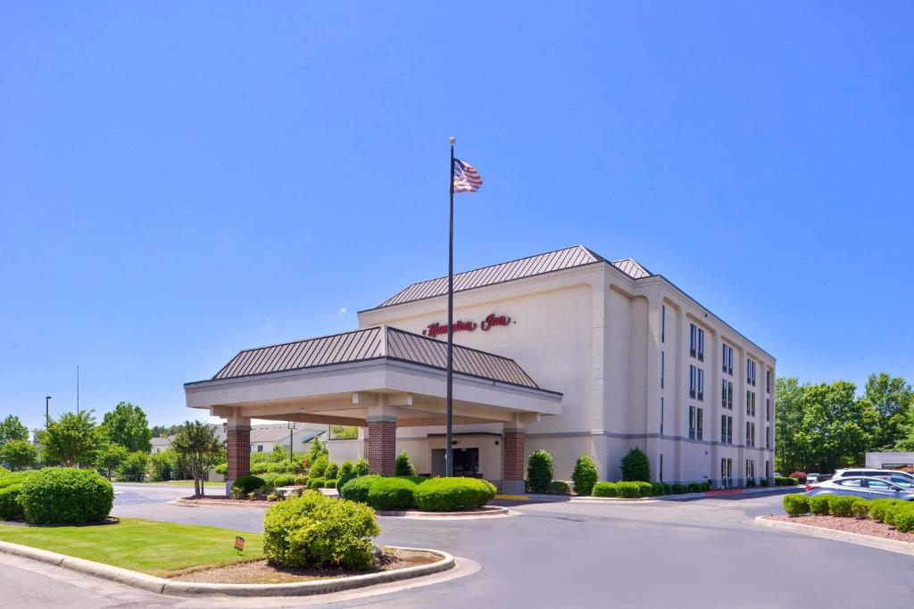 un edificio de oficinas con una bandera americana delante en Hampton Inn by Hilton Decatur, en Decatur