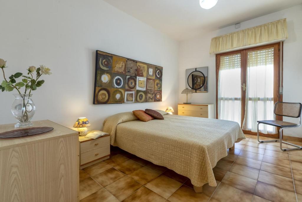 a bedroom with a bed and a desk and a chair at Villa Brandinu in Sassari