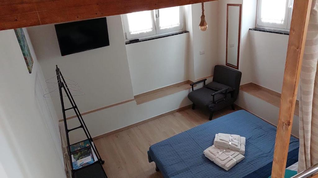 Zimmer mit einem Bett, einer Leiter und einem Stuhl in der Unterkunft Home & Bed Spartano in Sapri