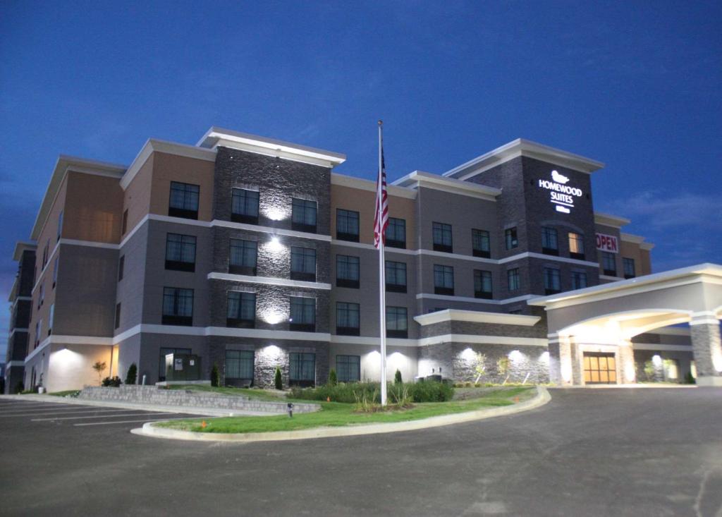 un gran edificio con una bandera americana delante de él en Homewood Suites By Hilton Dubois, Pa, en DuBois