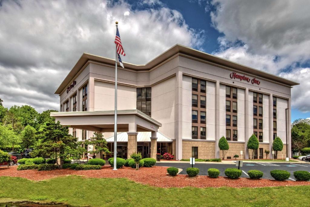 Um edifício de escritórios com uma bandeira americana à frente. em Hampton Inn Elizabeth City em Elizabeth City