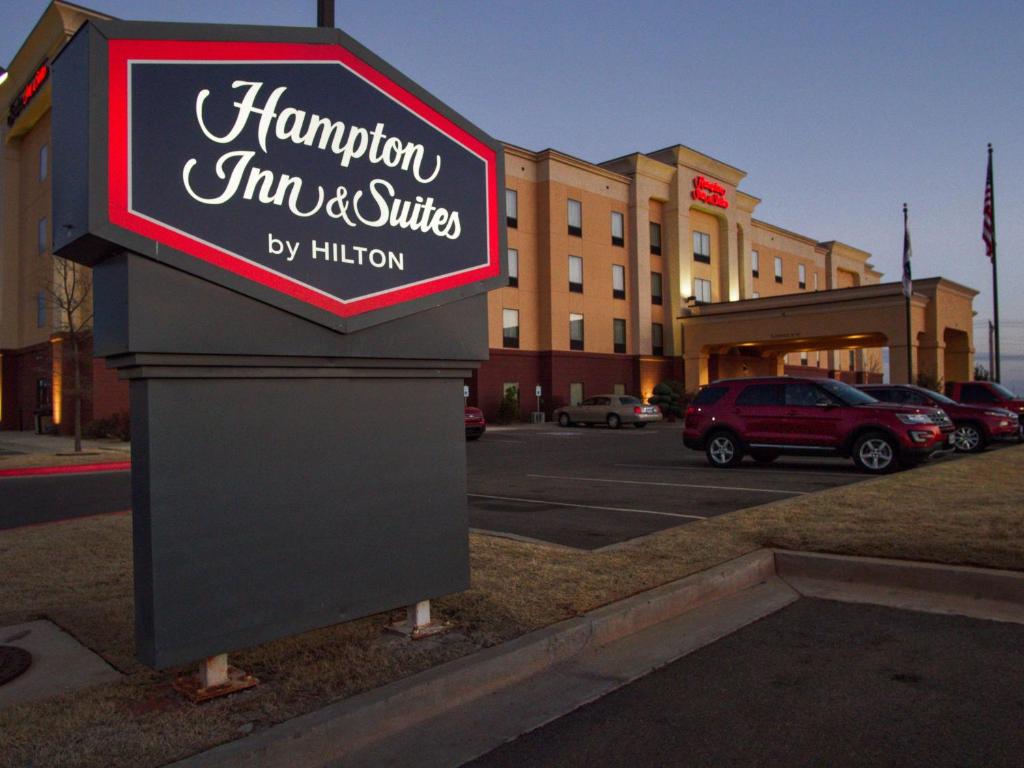 a hampton inn and suites sign in front of a parking lot at Hampton Inn & Suites Elk City in Elk City