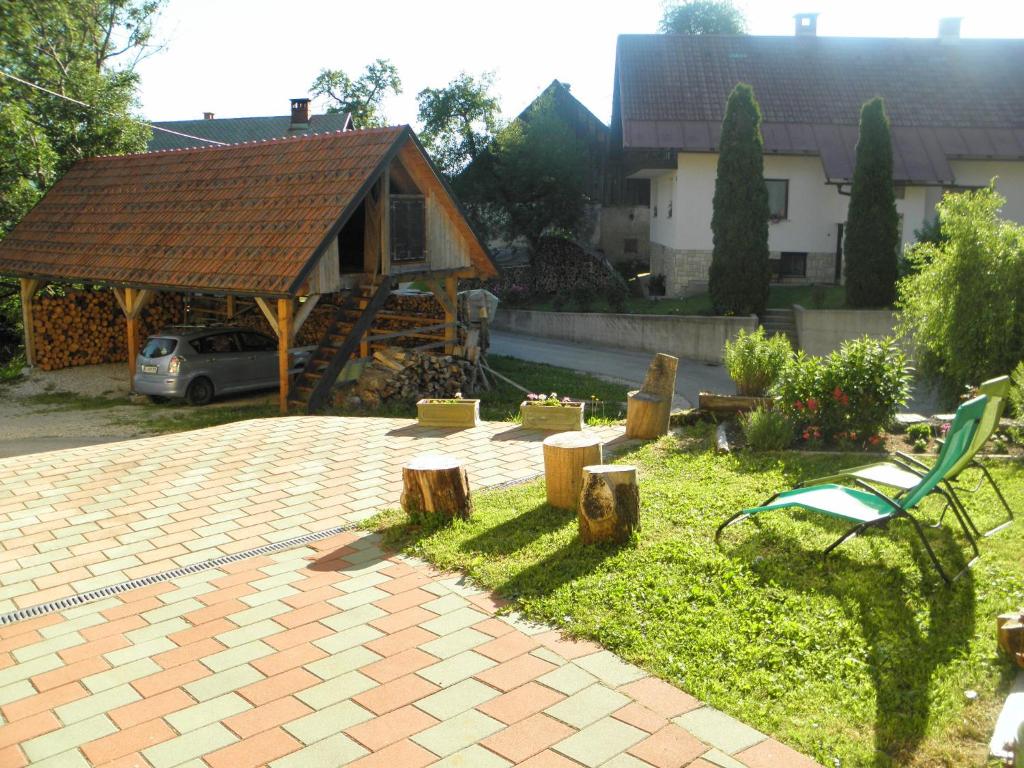 einen Garten mit einem Pavillon, einer Bank und einem Haus in der Unterkunft Tubej turist farm - wooden hayloft in Bohinjska Bistrica
