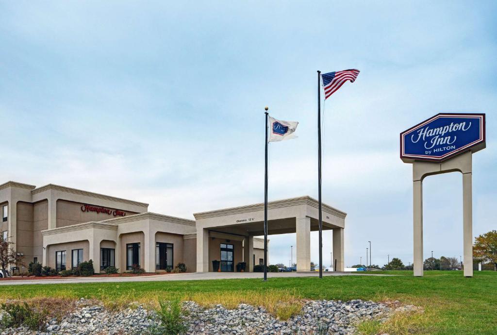 un edificio con dos banderas americanas y una señal en Hampton Inn Keokuk, en Keokuk