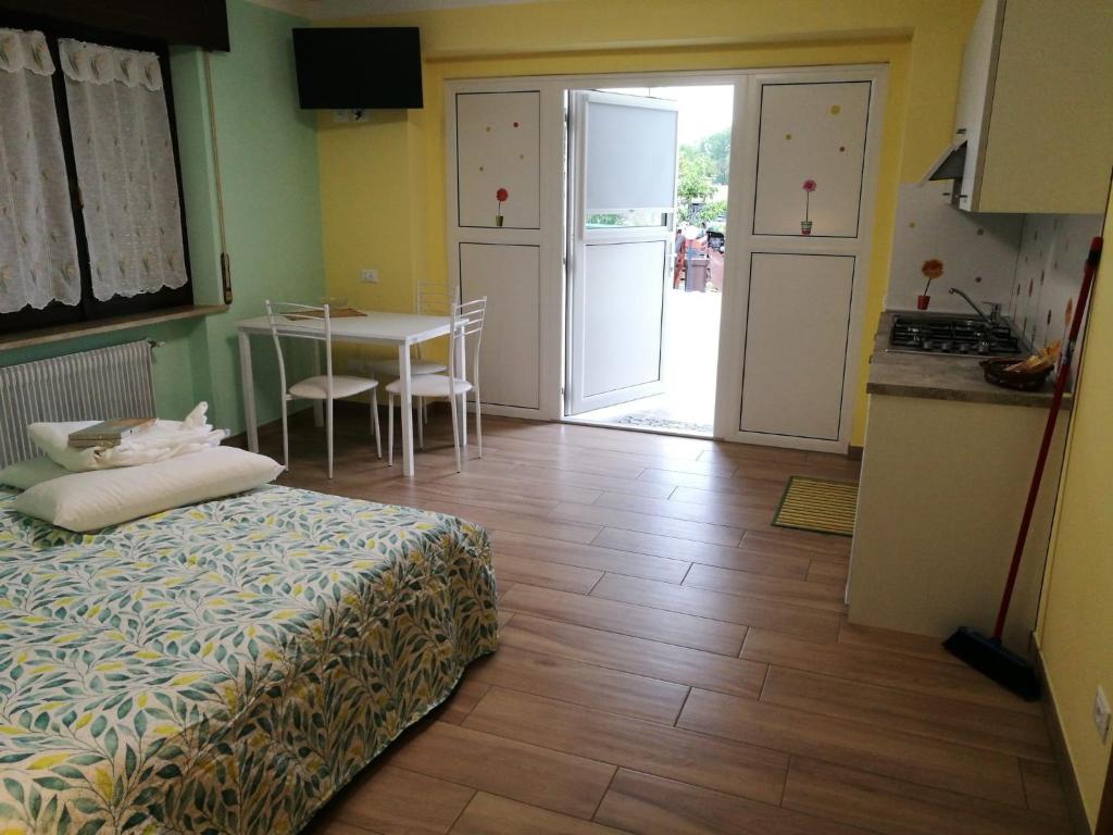um quarto com uma cama e uma cozinha com uma mesa em Colori nel Parco 2 em Cesiomaggiore