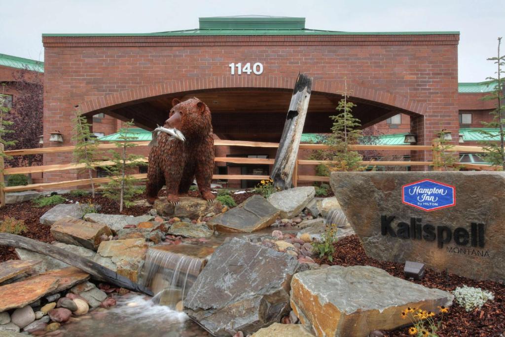 um urso castanho parado em frente a uma ponte em Hampton Inn Kalispell em Kalispell