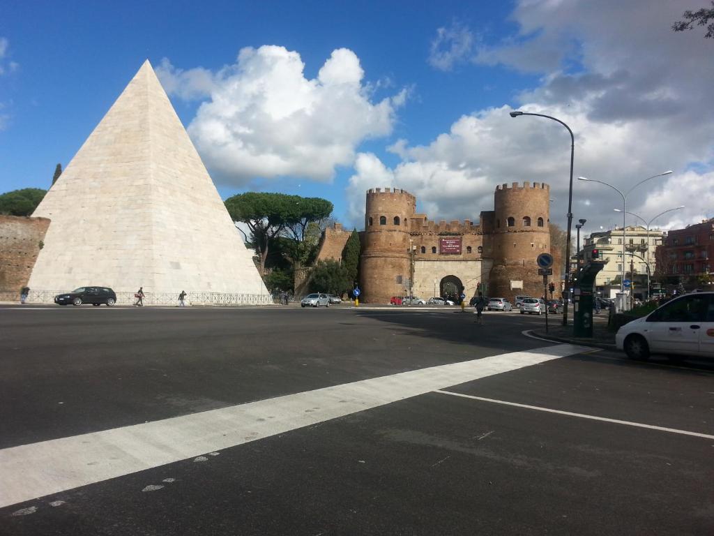 a building with a pyramid in front of a street at LILIUM HOUSE Apts in Rome