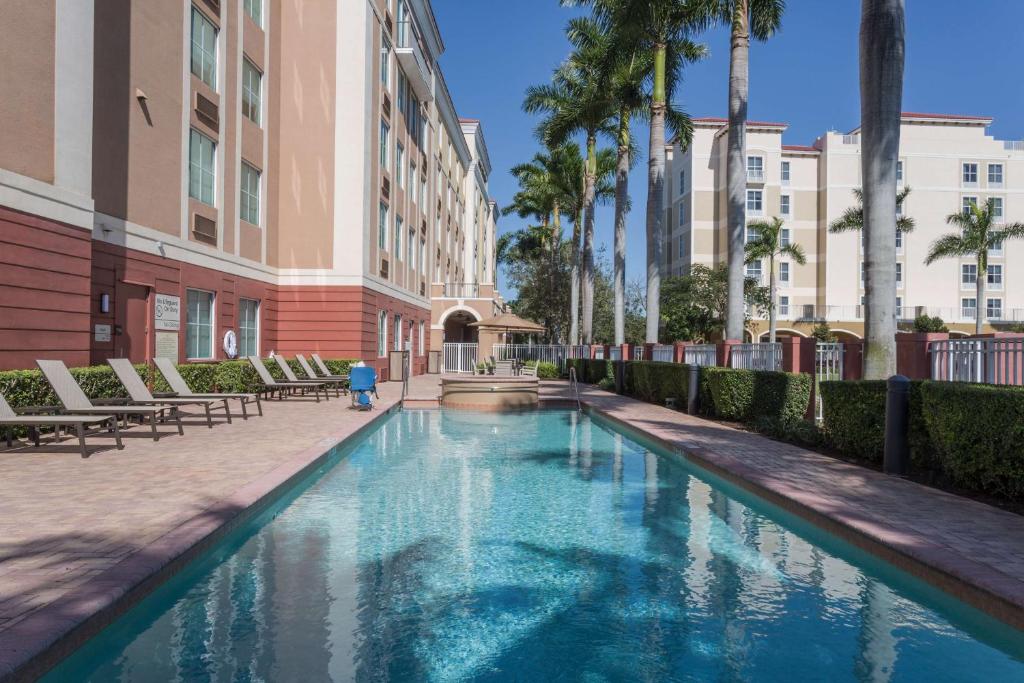 - une piscine dans la cour d'un immeuble avec des palmiers dans l'établissement Hampton Inn & Suites Fort Lauderdale - Miramar, à Miramar