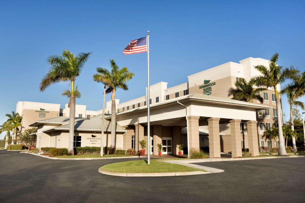 un edificio con una bandera americana delante de él en Homewood Suites Fort Myers Airport - FGCU en Fort Myers