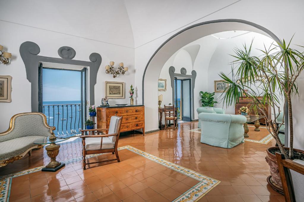 un arco en una sala de estar con sillas y mesas en Albergo Miramare Positano, en Positano