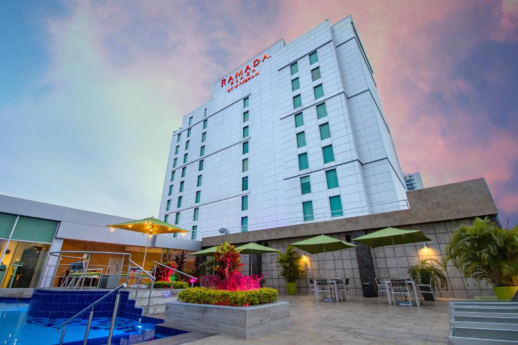 um hotel com piscina em frente a um edifício em Ramada Plaza by Wyndham Panama Punta Pacifica em Cidade do Panamá