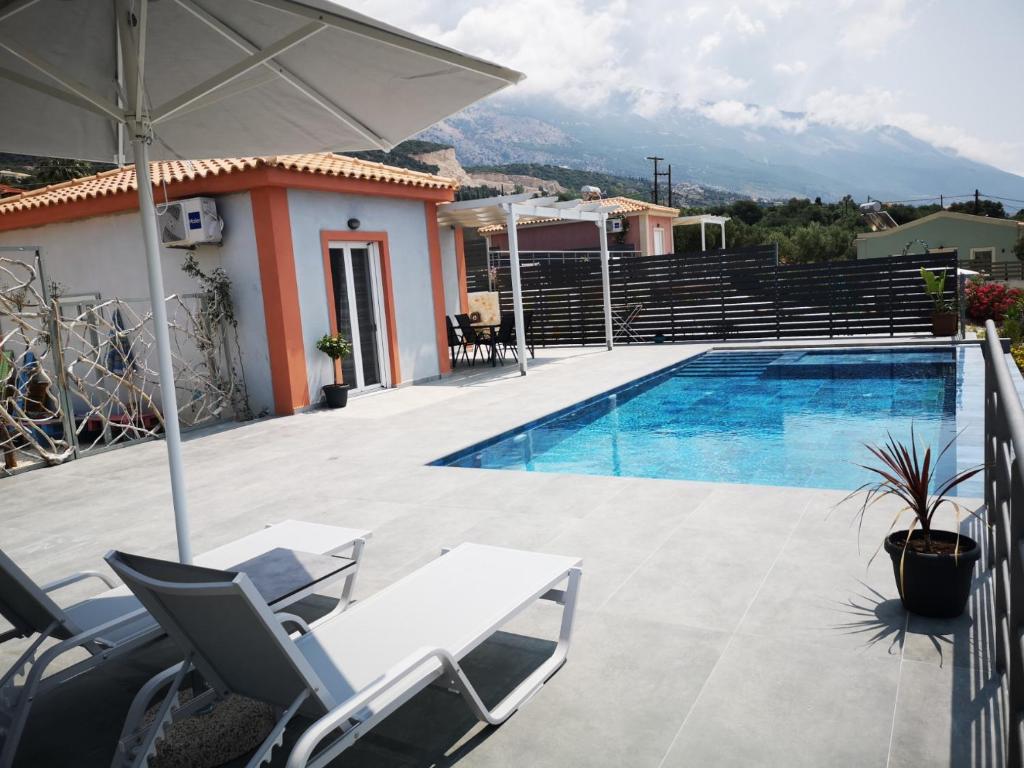 a villa with a swimming pool and a house at Fiora Villas in Trapezaki