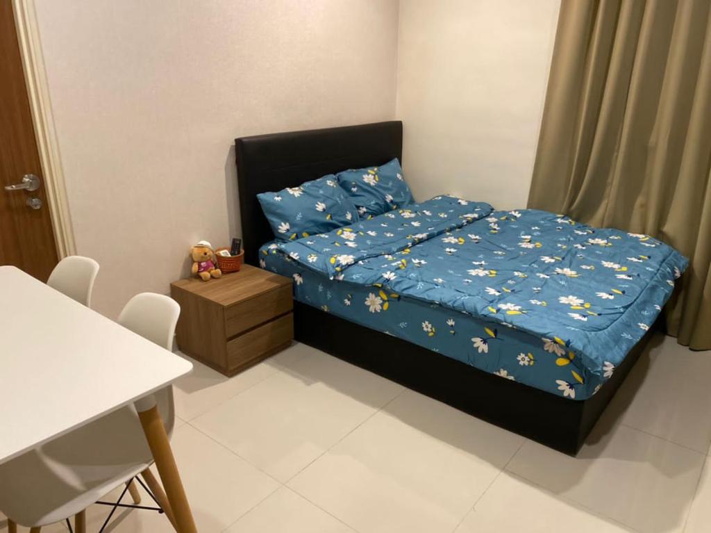 een kleine slaapkamer met een bed en een tafel bij Kuching Kozi Square Homestay Apartment in Kuching