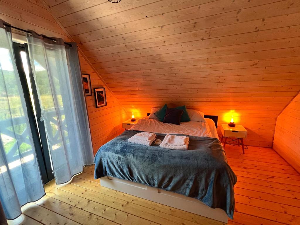 a bedroom with a bed in a wooden room at Śnieżna Chatka - Sosnówka Karpacz in Sosnówka