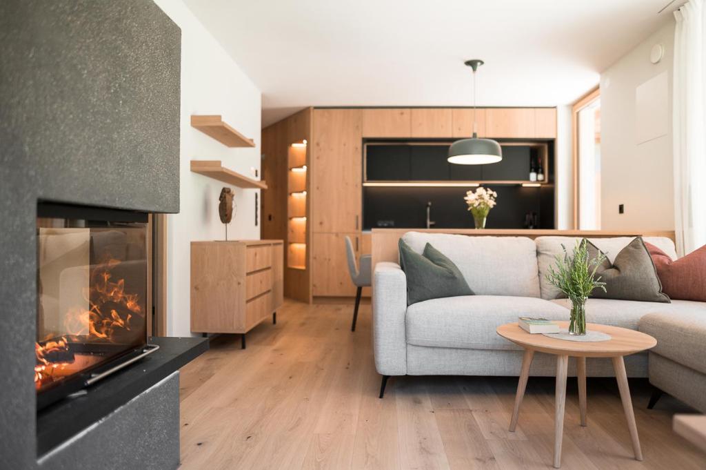 een woonkamer met een bank en een open haard bij Sunnseit Apartment 3 in Ultimo