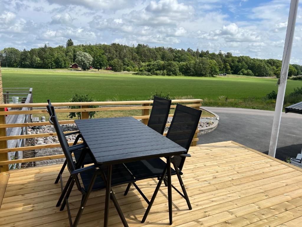 a black table and chairs on a wooden deck at Studio Hamra in Särö