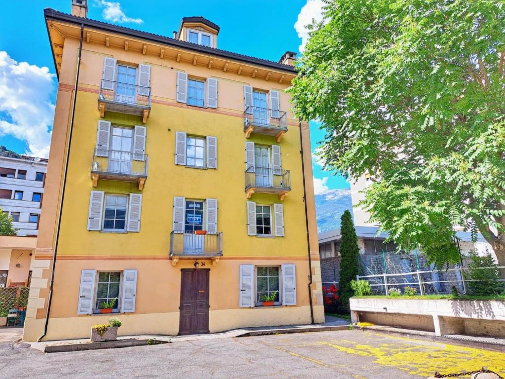 un edificio amarillo con ventanas y balcones en Casa Alpina - Aosta, en Aosta