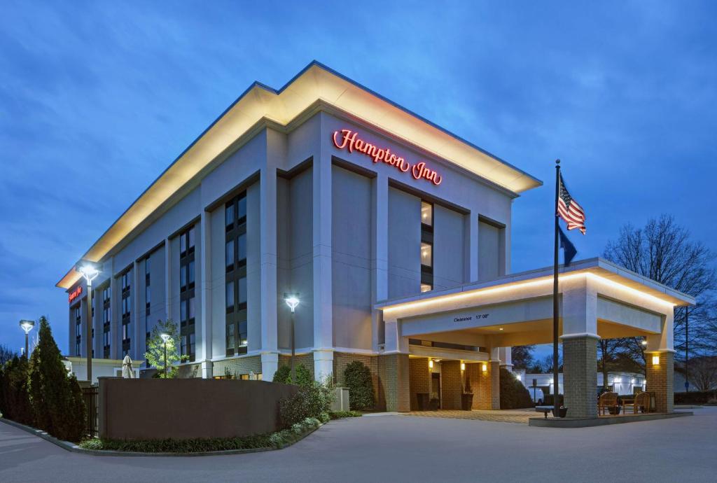 a hotel building with an american flag in front of it at Hampton Inn Greenville/Woodruff Road in Greenville