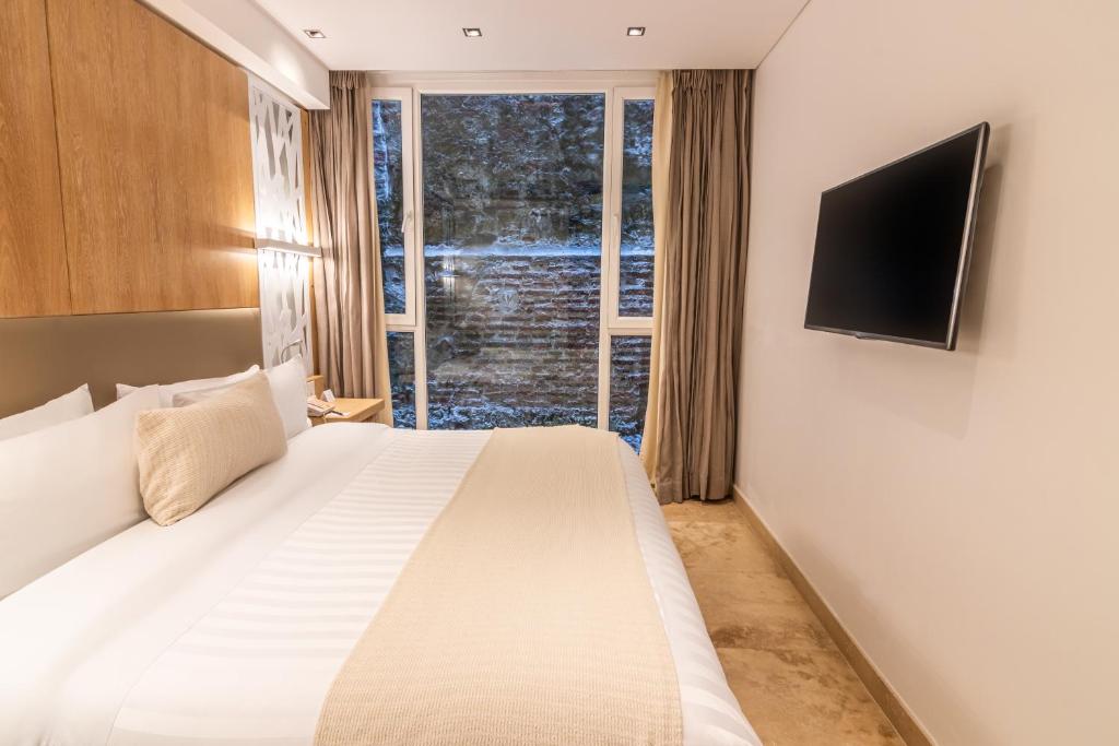 Postel nebo postele na pokoji v ubytování GHL Arsenal Hotel