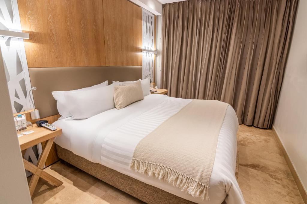 Postel nebo postele na pokoji v ubytování GHL Arsenal Hotel