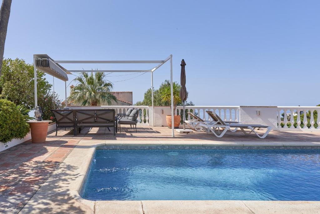 a swimming pool with a table and a picnic table next to a house at Casa Bonita in Salobreña
