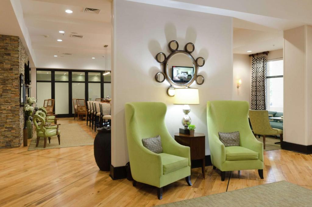 uma sala de estar com duas cadeiras verdes e um espelho em Hampton Inn Hickory em Hickory