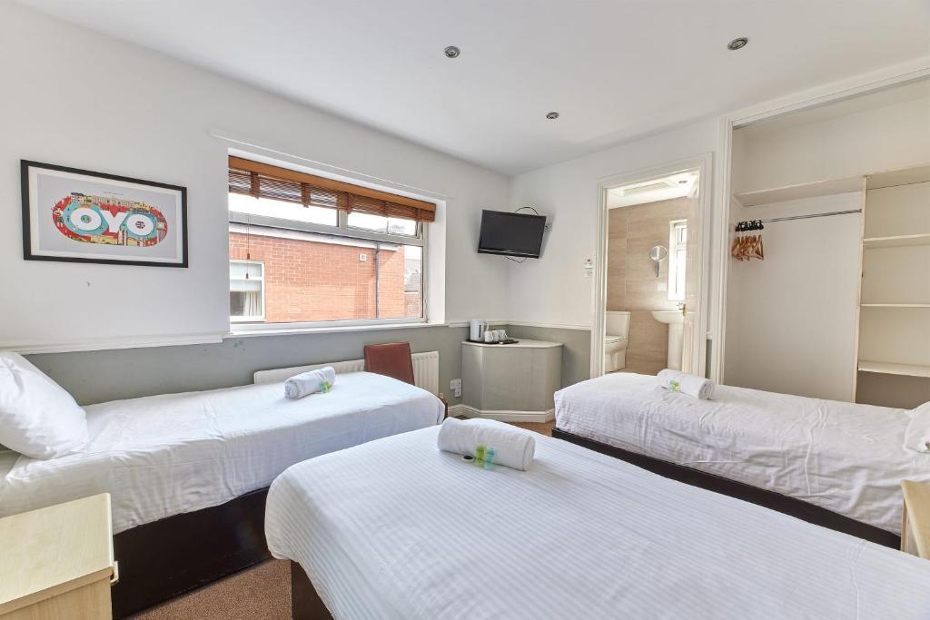 a room with two beds and a couch at Properties Unique Dene Rooms - Triple Room in Newcastle upon Tyne