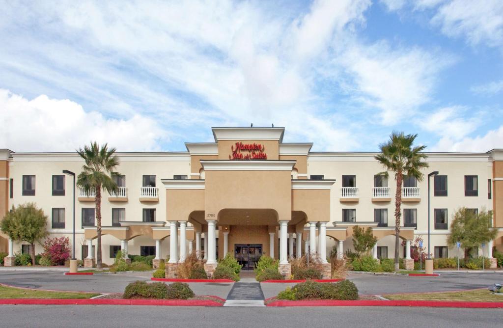赫米特的住宿－Hampton Inn & Suites by Hilton Hemet Menifee Murrieta，一座棕榈树环绕的大建筑