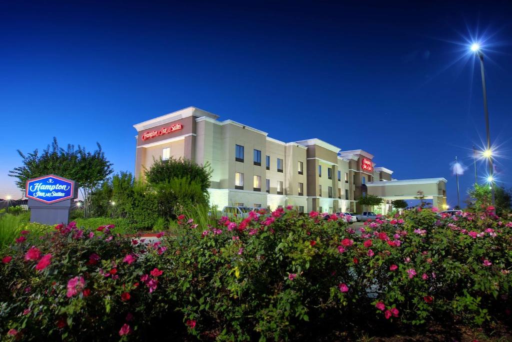 un hotel con flores frente a un edificio en Hampton Inn & Suites Houston Rosenberg, en Rosenberg
