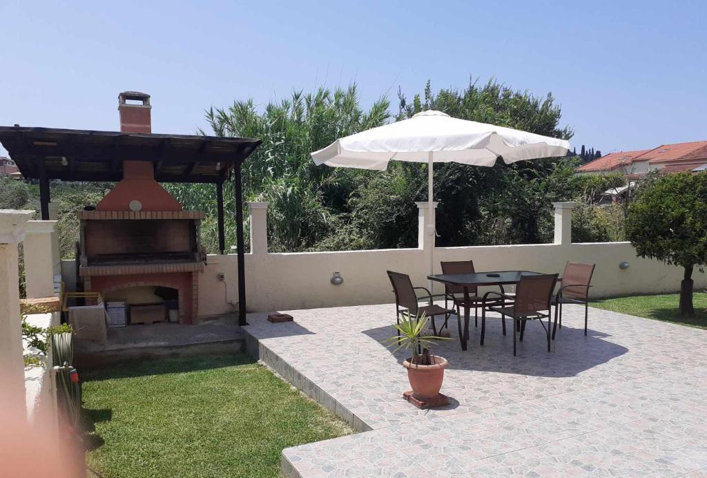 a patio with a table and an umbrella and a grill at Casa Raymo in Kanálion