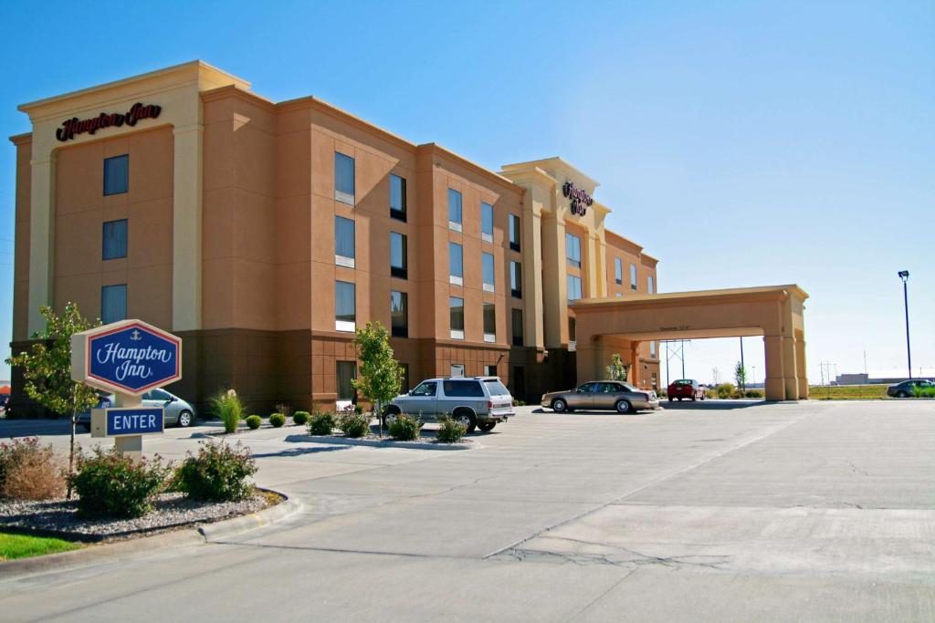 ein Hotel mit einem Schild vor einem Parkplatz in der Unterkunft Hampton Inn Hays-North of I-70 in Hays