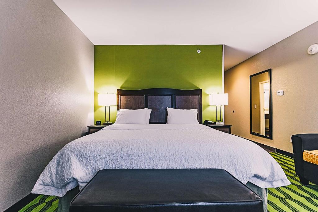 a bedroom with a large bed with a green wall at Hampton Inn Niagara Falls/ Blvd in Niagara Falls