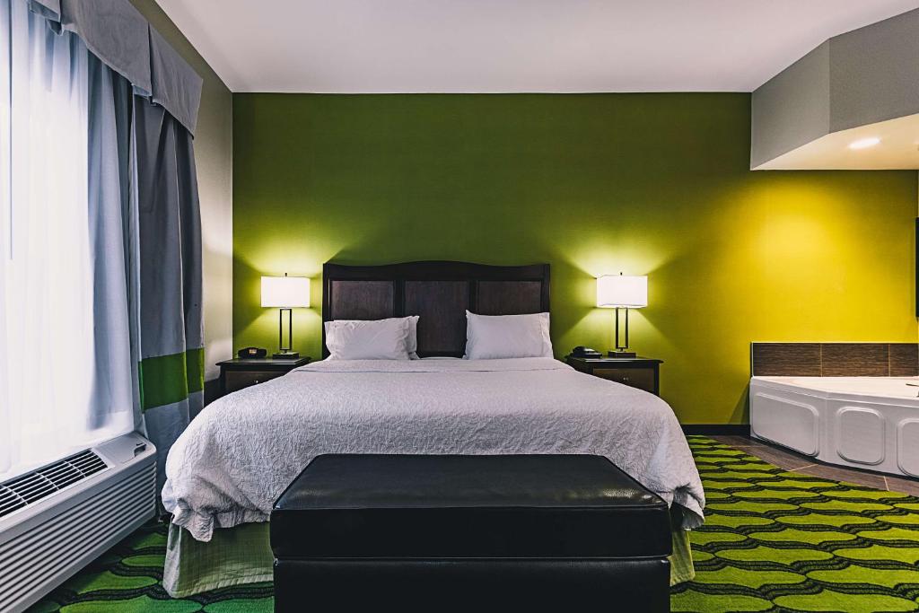 a bedroom with a bed and a green wall at Hampton Inn Niagara Falls/ Blvd in Niagara Falls