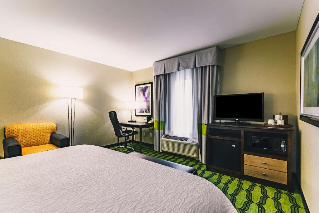 a hotel room with a bed and a flat screen tv at Hampton Inn Niagara Falls/ Blvd in Niagara Falls