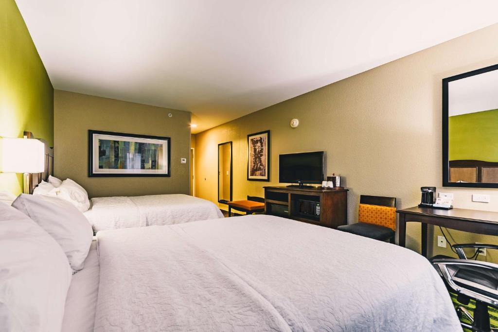 a hotel room with two beds and a desk at Hampton Inn Niagara Falls/ Blvd in Niagara Falls