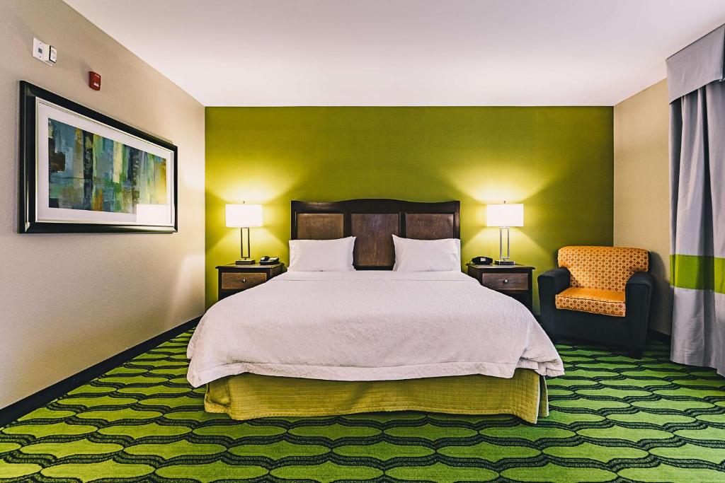 a bedroom with a large bed and a chair at Hampton Inn Niagara Falls/ Blvd in Niagara Falls