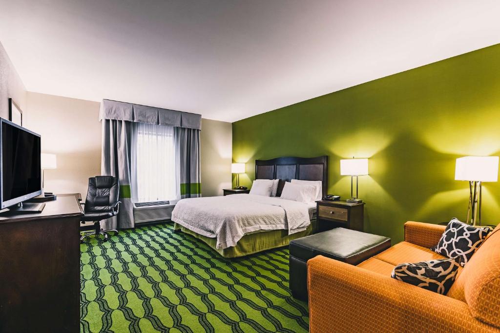 a hotel room with a bed and a couch at Hampton Inn Niagara Falls/ Blvd in Niagara Falls