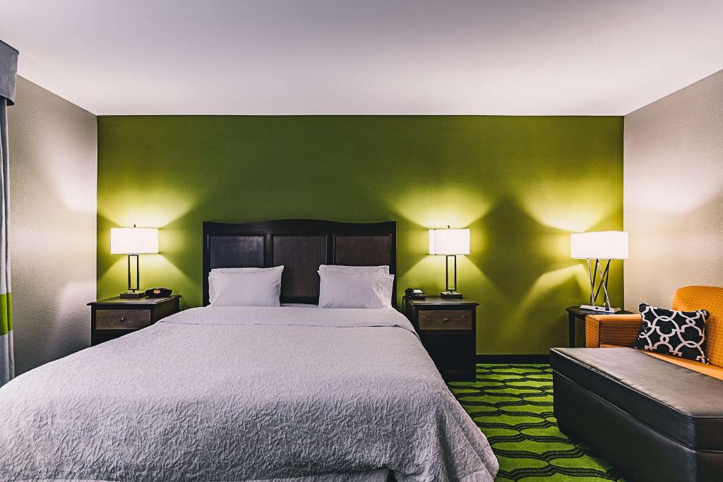 a bedroom with a bed and a green wall at Hampton Inn Niagara Falls/ Blvd in Niagara Falls