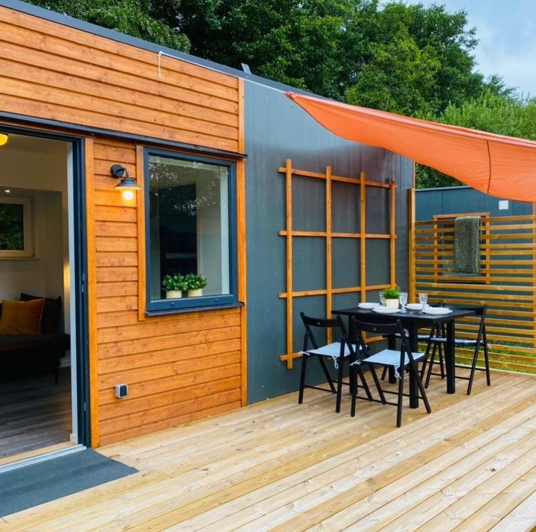 una casa pequeña con una mesa y sillas en una terraza en Lomma Camping, en Lomma