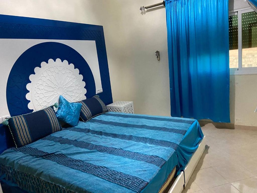 een slaapkamer met een bed met een blauw en wit hoofdeinde bij 4 Seasons Guesthouse Gafait 