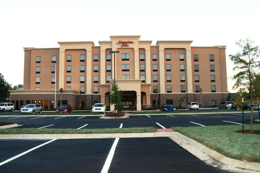 un grand bâtiment avec un parking en face de celui-ci dans l'établissement Hampton Inn Jackson/Flowood - Airport Area MS, à Luckney