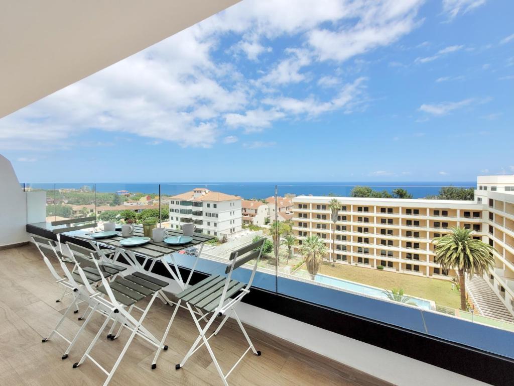 a balcony with a table and chairs and a large window at Mar Azul in Puerto de la Cruz