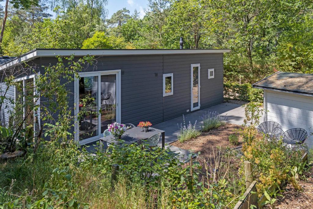 een klein huisje midden in een tuin bij lodge De Winterkoning in Nunspeet