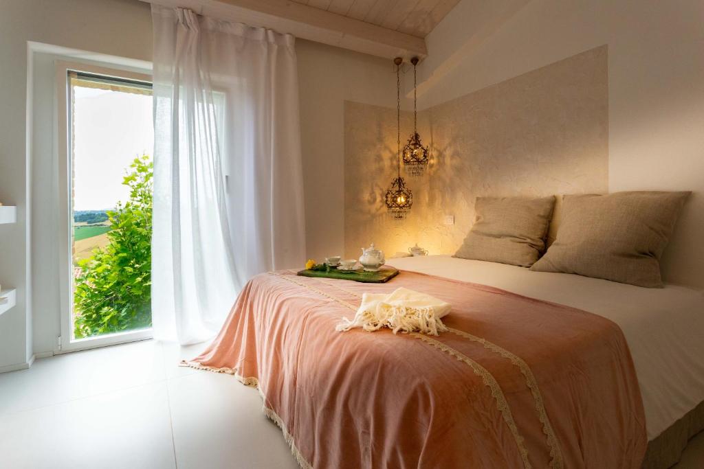 una camera da letto con un letto e una grande finestra di Mia House - Alloggio da sogno a Civitanova Alta a Civitanova Alta