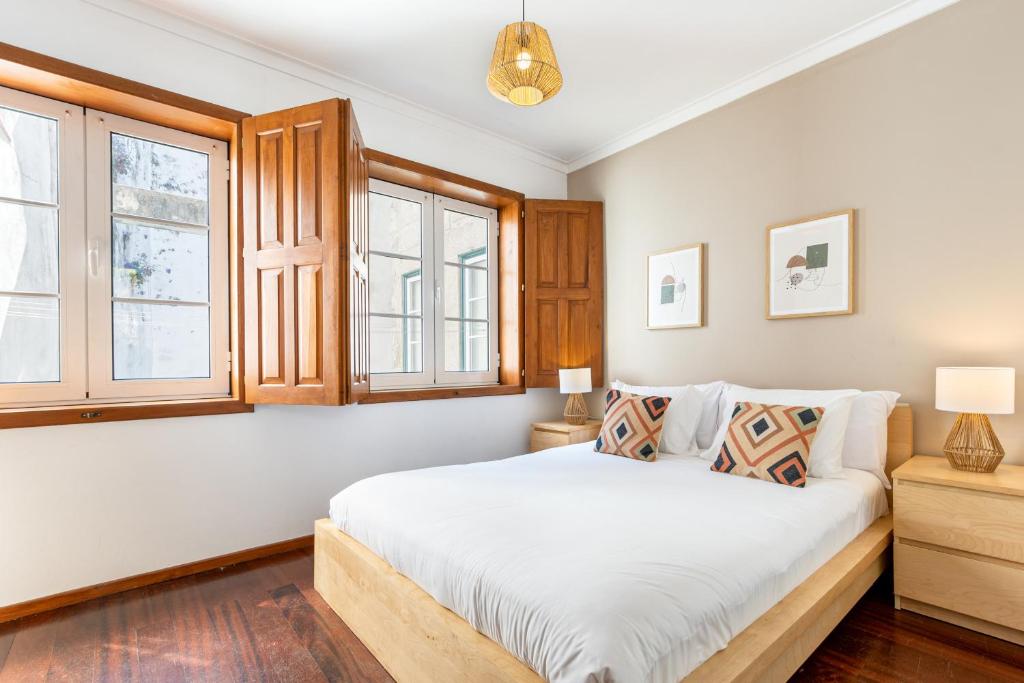 ブラガにあるSé Apartamentos - Casa da Séのベッドルーム(大きな白いベッド1台、窓付)