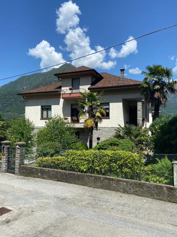 a white house with a mountain in the background at CA' DEI PAOLI in Pieve Vergonte
