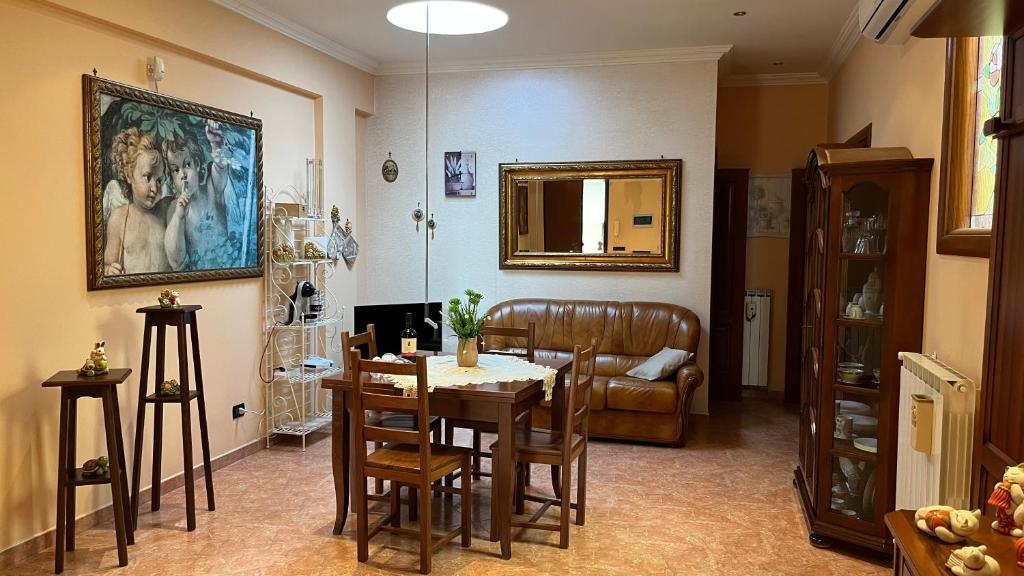 een woonkamer met een tafel en een bank bij Casa Giusy in San Marzano di San Giuseppe