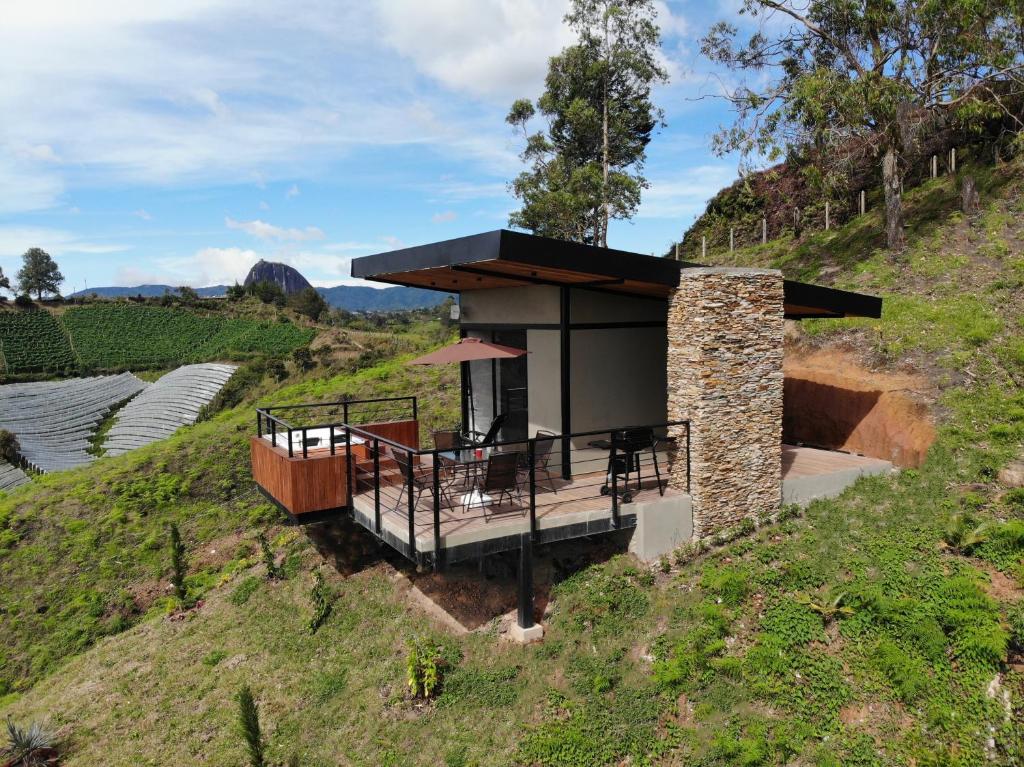 una casa en la cima de una colina con terraza en Glamping en Guatape Wifi Jacuzzi, en Guatapé