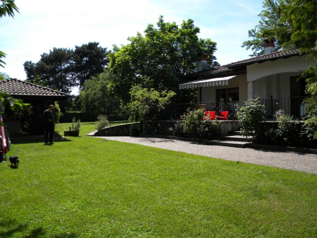 eine Person, die in einem Hof neben einem Haus steht in der Unterkunft Villa Daniela in Lesa